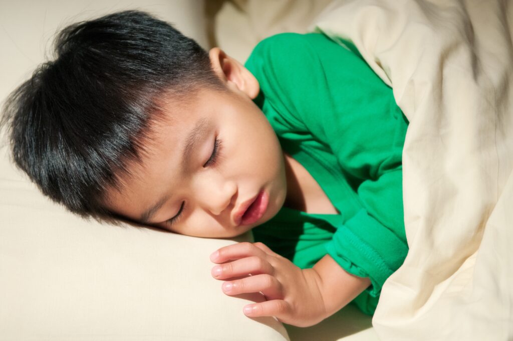 Young child sleeping with their mouth slightly open.