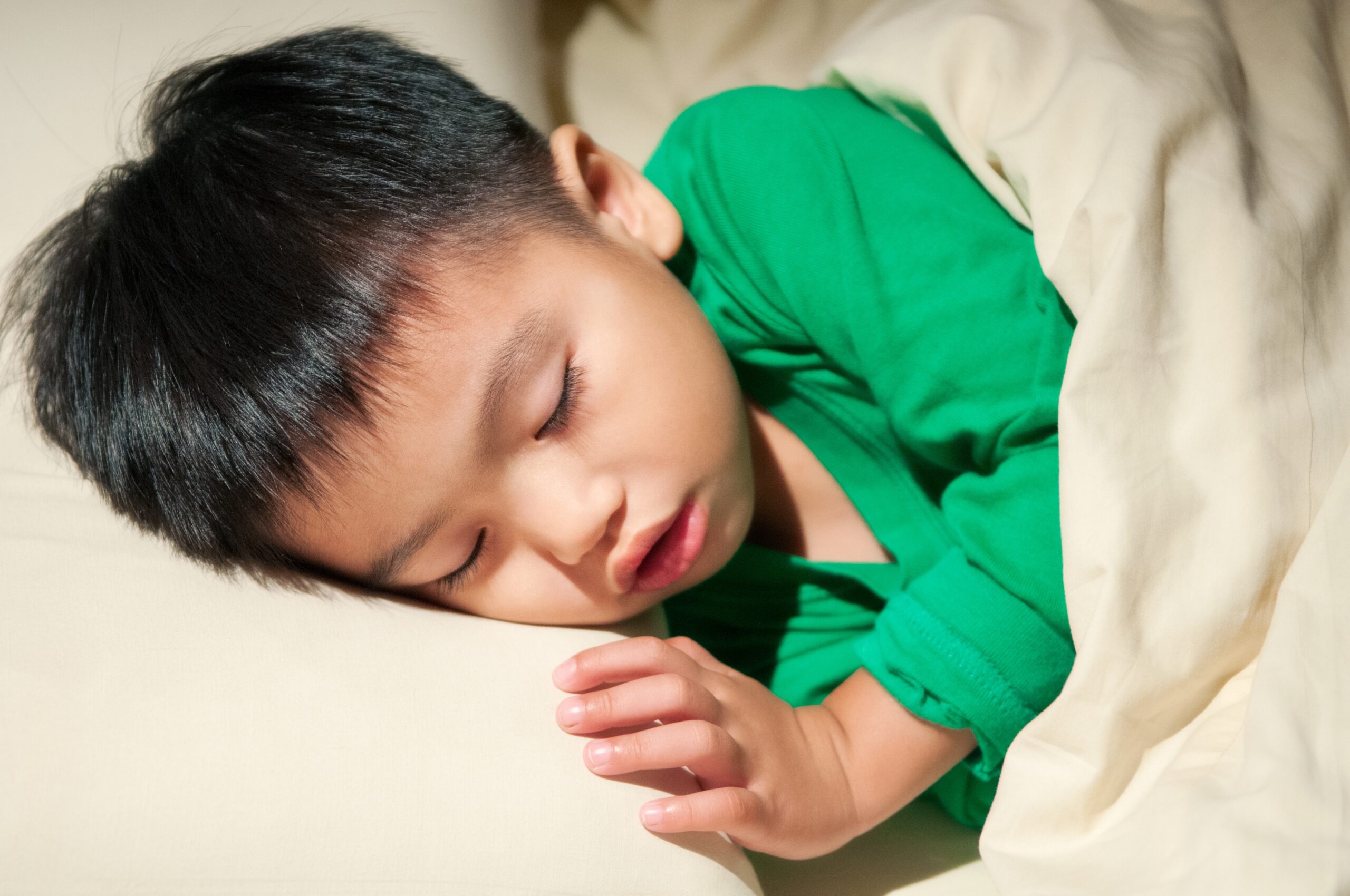 Young child sleeping with their mouth slightly open.